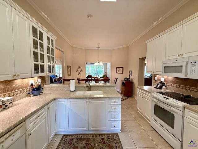 kitchen with white appliances, a sink, a peninsula, white cabinets, and crown molding