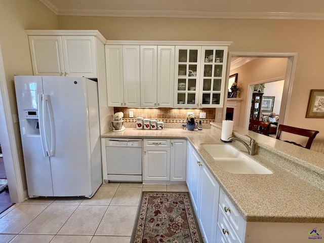 kitchen featuring white appliances, a sink, decorative backsplash, white cabinets, and crown molding
