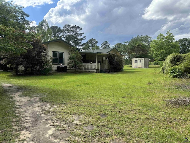174 Cabero Rd, Hawkinsville, GA 31036 - view of grassy yard with a storage shed, an outbuilding, and covered porch