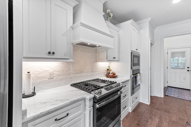 kitchen featuring gas stove, custom exhaust hood, dark wood finished floors, light stone counters, and ornamental molding