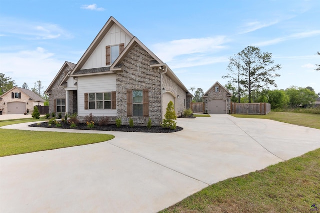 craftsman inspired home featuring curved driveway, board and batten siding, a garage, brick siding, and an outbuilding