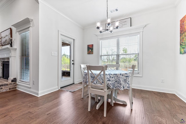 dining area featuring a chandelier, wood finished floors, baseboards, ornamental molding, and a fireplace