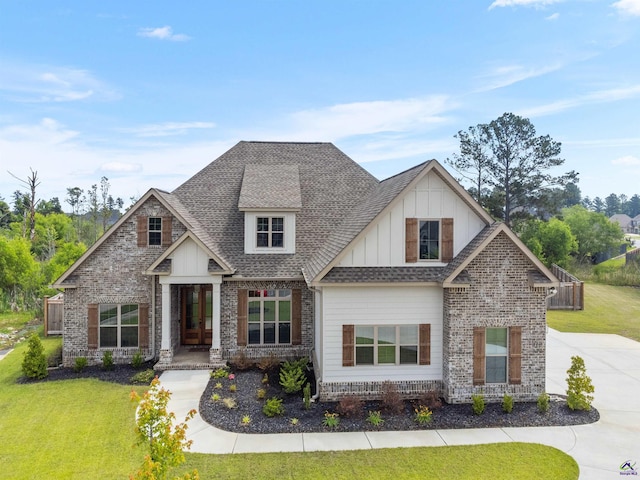craftsman inspired home featuring board and batten siding, a front lawn, a shingled roof, and brick siding