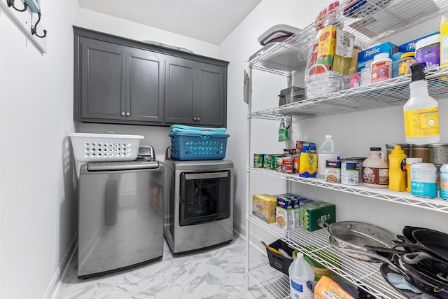 laundry area with light marble finish flooring, washer and dryer, cabinet space, and baseboards