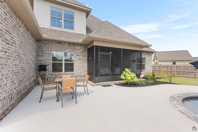 view of patio / terrace with a sunroom, fence, and outdoor dining area