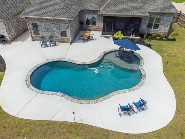 swimming pool featuring a patio area and a sunroom
