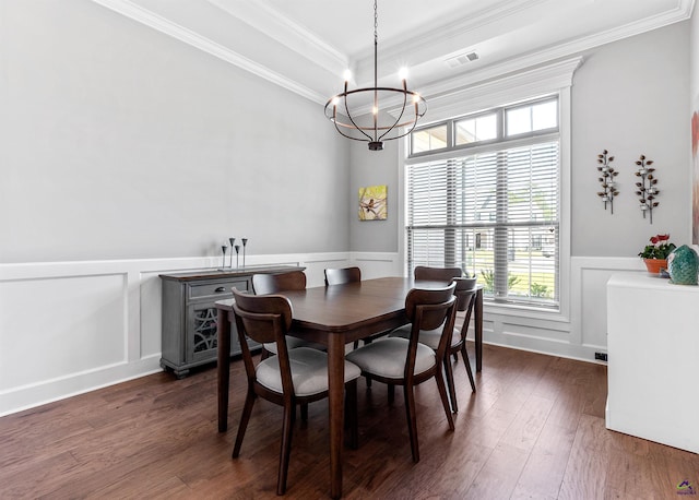 dining area with a chandelier, crown molding, wainscoting, a decorative wall, and dark wood finished floors