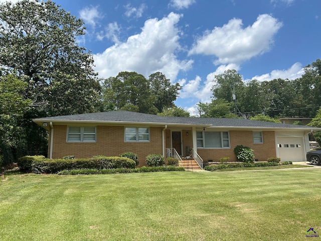 ranch-style house with brick siding, a garage, and a front lawn