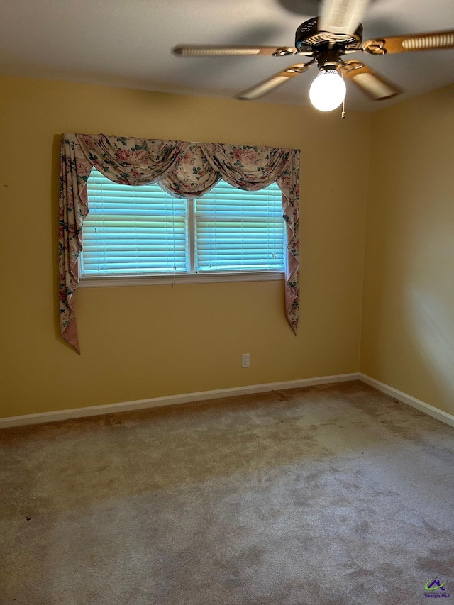 unfurnished room featuring a ceiling fan, carpet flooring, and baseboards