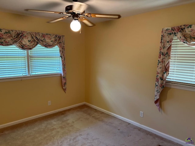 unfurnished room featuring plenty of natural light, ceiling fan, carpet floors, and baseboards