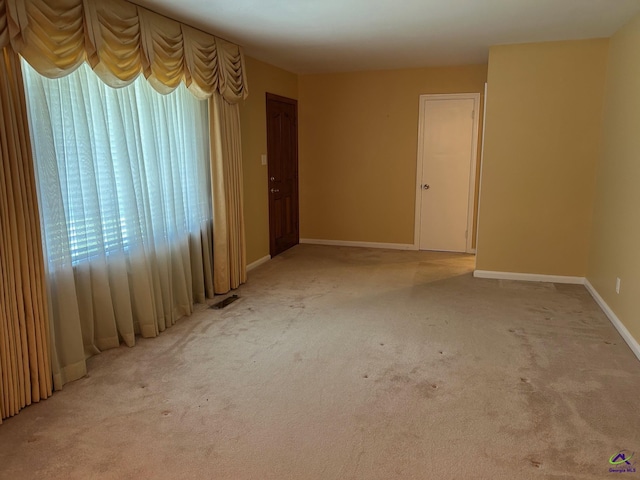 empty room with light carpet and baseboards