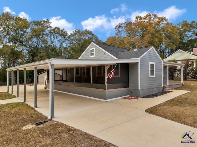 257 Macon Rd, Reynolds, GA 31076 - view of front of home featuring concrete driveway, a carport, a sunroom, and roof with shingles