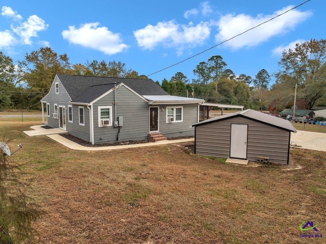257 Macon Rd, Reynolds, GA 31076 - rear view of house with entry steps, a storage unit, a lawn, and an outbuilding