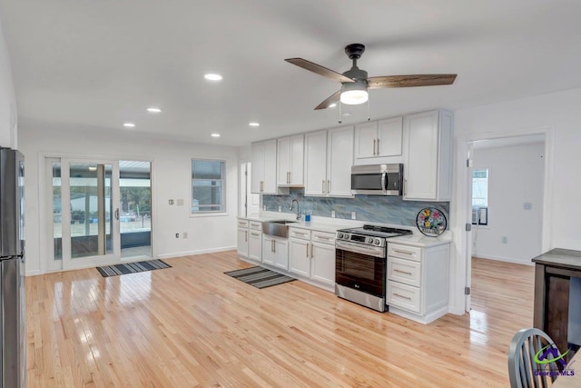 257 Macon Rd, Reynolds, GA 31076 - kitchen with appliances with stainless steel finishes, a sink, backsplash, light wood-style floors, and light countertops