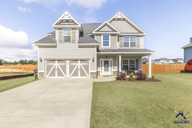 craftsman-style house featuring driveway, stone siding, a porch, and a shingled roof