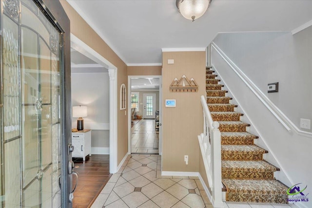 entryway featuring stairway, crown molding, baseboards, and light tile patterned floors
