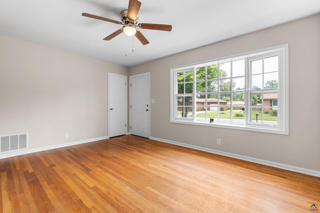 unfurnished room with baseboards, light wood-type flooring, and ceiling fan