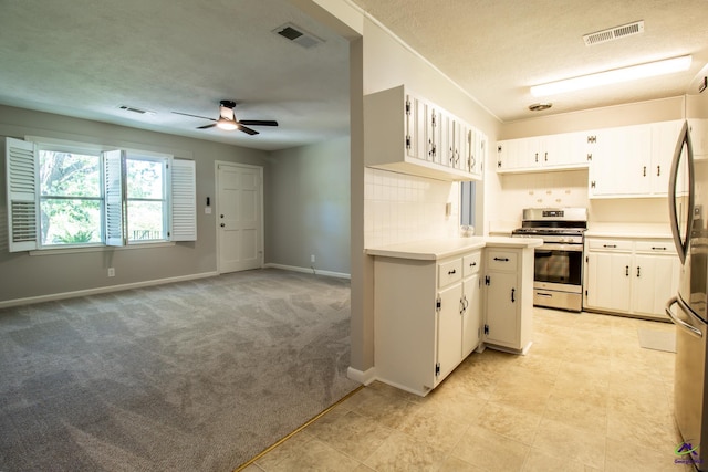 kitchen featuring stainless steel appliances, light countertops, light carpet, ceiling fan, and a textured ceiling