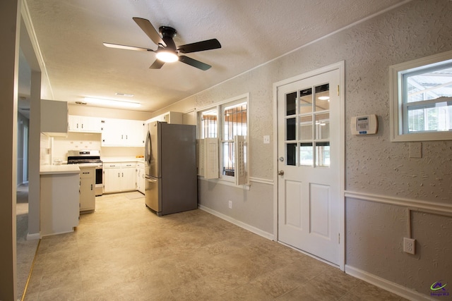 kitchen with stainless steel appliances, a ceiling fan, healthy amount of natural light, light countertops, and a textured ceiling