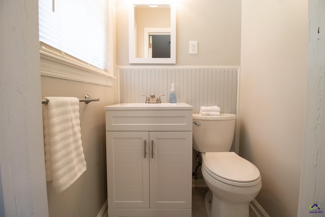bathroom with wainscoting, toilet, and vanity