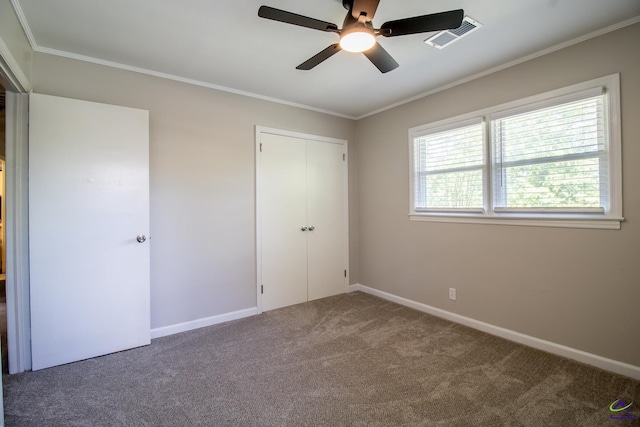 unfurnished bedroom with carpet, crown molding, a closet, baseboards, and a ceiling fan