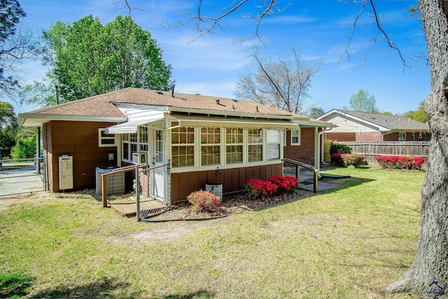 back of property with central AC, roof with shingles, and a sunroom