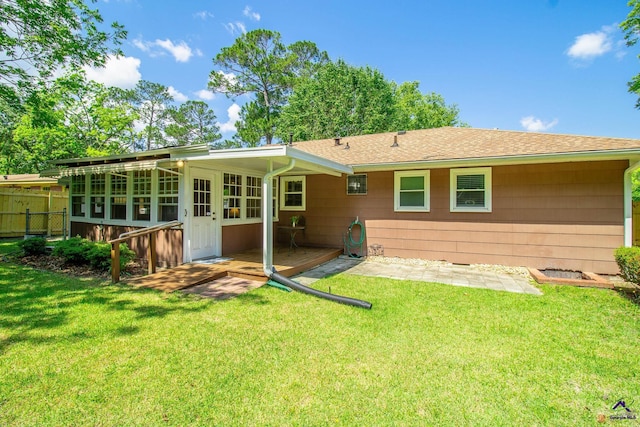 back of house featuring a sunroom and a shingled roof