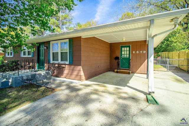 view of front of home with fence, driveway, and a carport