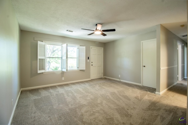 carpeted spare room featuring a ceiling fan, baseboards, and a textured ceiling