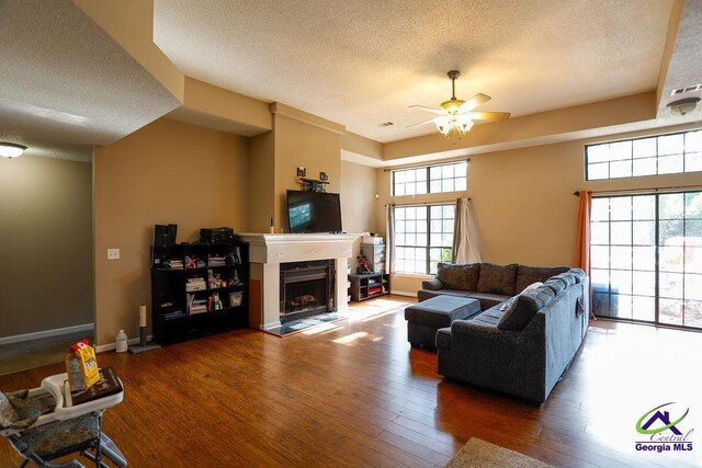 209 Ridgestone, Warner Robins, GA 31088 - living area featuring a textured ceiling, a ceiling fan, a fireplace, wood finished floors, and baseboards