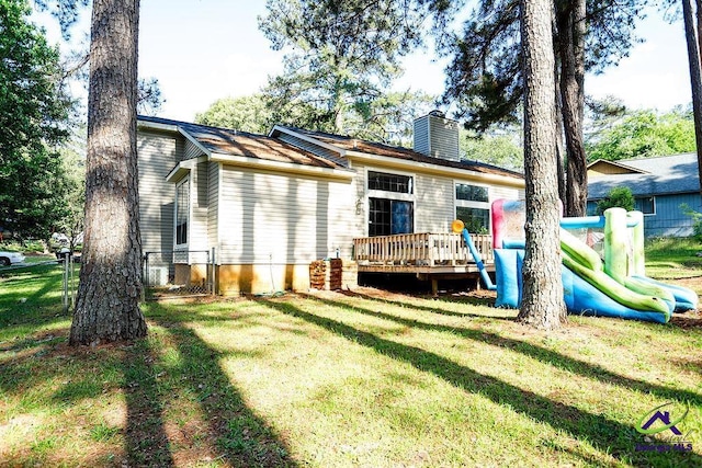 209 Ridgestone, Warner Robins, GA 31088 - back of house with a chimney, a wooden deck, and a playground