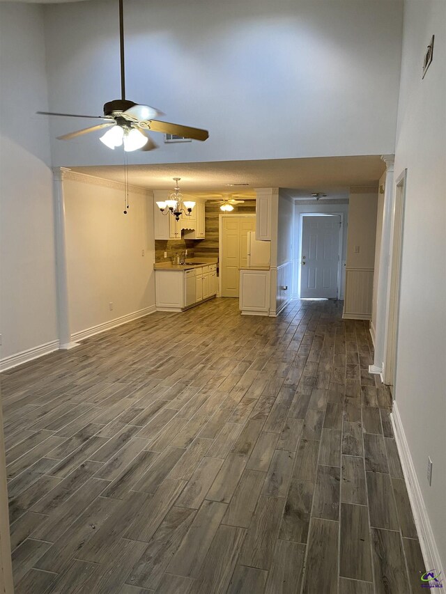 310 Westcliff Ctr, Warner Robins, GA 31088 - unfurnished living room with dark wood-style flooring, ceiling fan, baseboards, a towering ceiling, and a sink