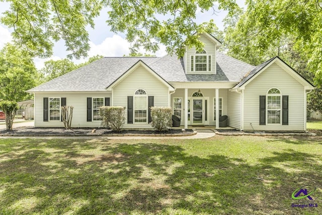view of front of house featuring roof with shingles, a front lawn, and covered porch