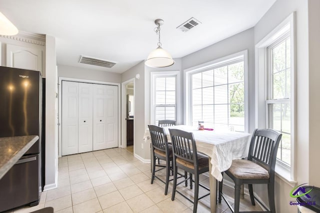 dining area featuring baseboards, healthy amount of natural light, and light tile patterned floors