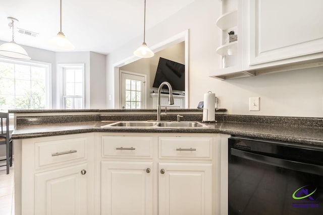 kitchen featuring dishwasher, a sink, plenty of natural light, and dark countertops