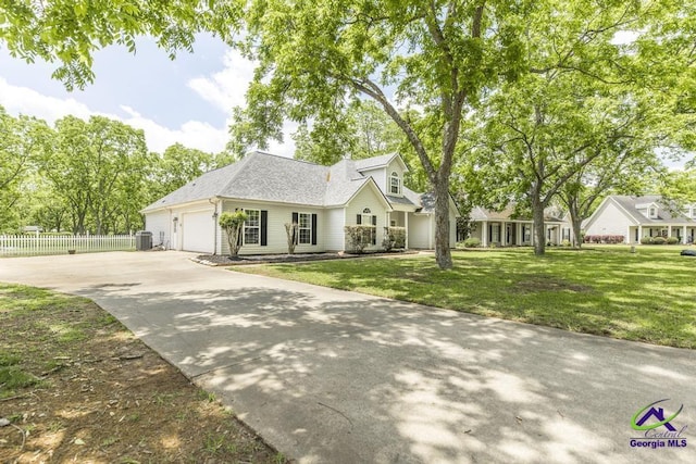 traditional-style house with concrete driveway, a garage, central AC, and a shingled roof