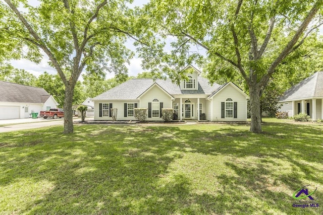 view of front of house with a front lawn, roof with shingles, and covered porch