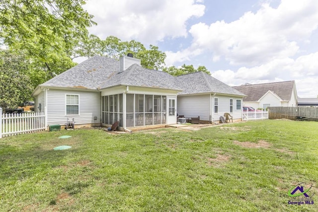 rear view of property with a sunroom, a chimney, and a shingled roof