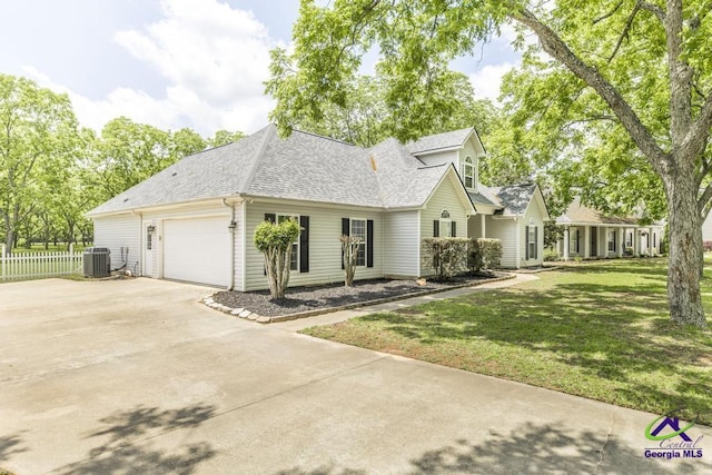 view of front of property with a shingled roof, driveway, central air condition unit, and a garage