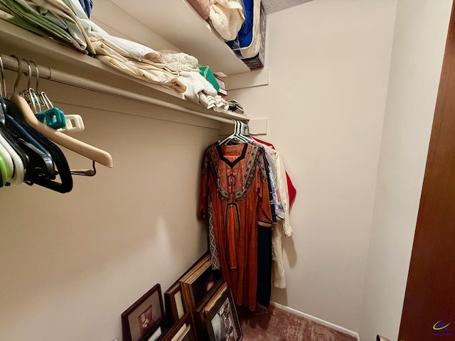 walk in closet featuring dark carpet
