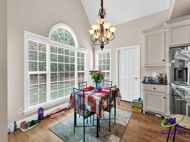 163 Broadleaf Dr, Macon, GA 31210 - dining room with a chandelier, wood finished floors, lofted ceiling, and ornamental molding