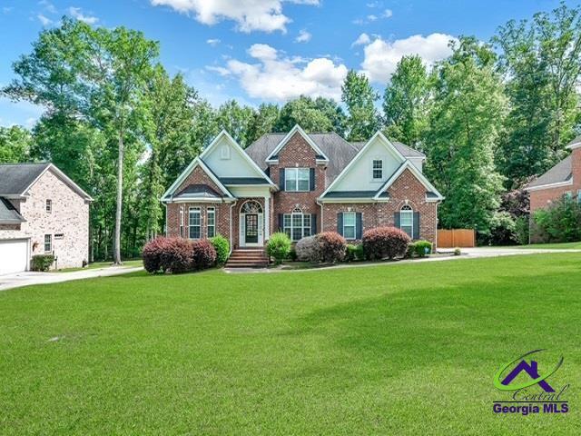163 Broadleaf Dr, Macon, GA 31210 - view of front facade with a front lawn, brick siding, and view of wooded area
