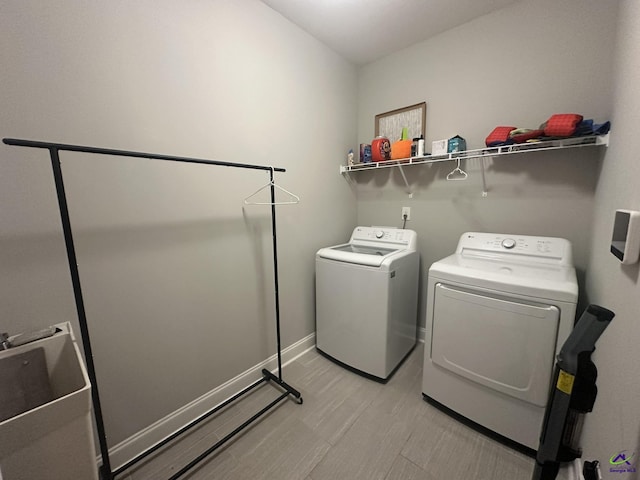 laundry room with washer and dryer and light wood-style floors