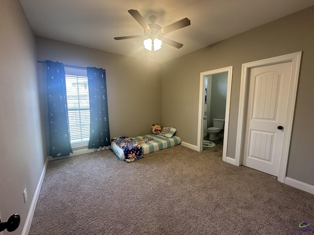 unfurnished bedroom featuring carpet, baseboards, ensuite bathroom, and a ceiling fan