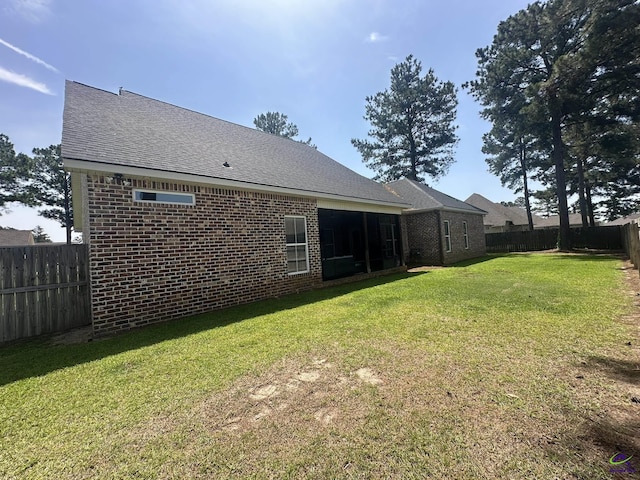 rear view of house with brick siding and roof with shingles