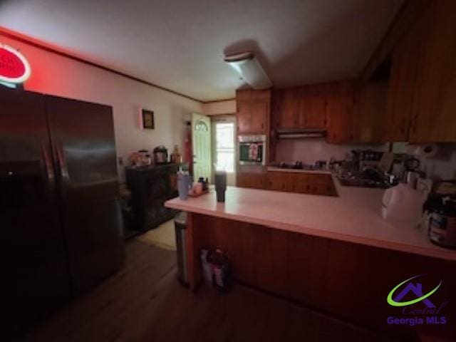 111 Mason Dr, Centerville, GA 31028 - kitchen with a peninsula, oven, brown cabinets, light countertops, and freestanding refrigerator