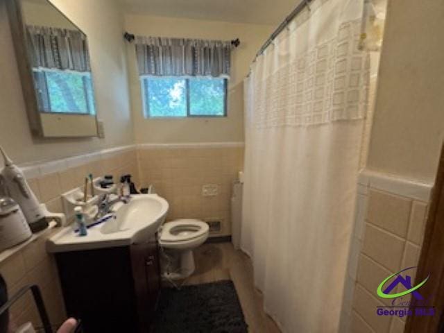111 Mason Dr, Centerville, GA 31028 - bathroom with toilet, tile walls, vanity, a wainscoted wall, and curtained shower