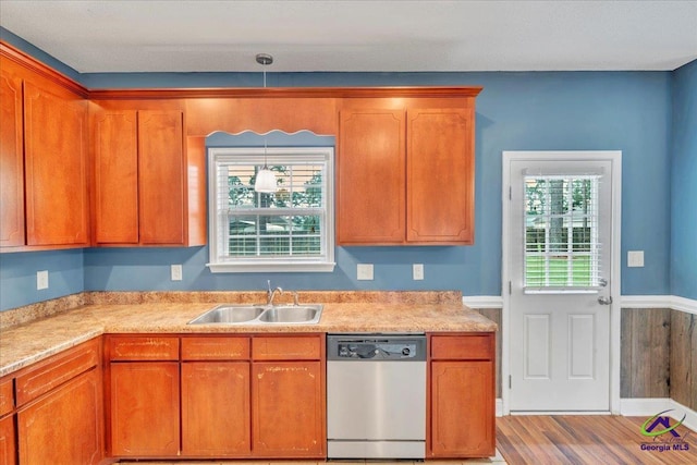 kitchen with dishwasher, a sink, light countertops, and wood finished floors