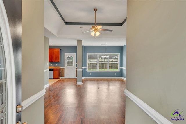 unfurnished living room featuring a ceiling fan, light wood finished floors, baseboards, and a chandelier