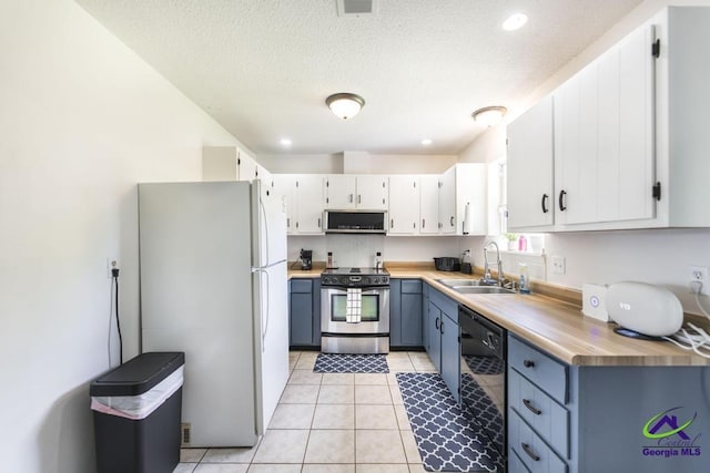 kitchen featuring stainless steel electric stove, freestanding refrigerator, dishwasher, a sink, and light countertops